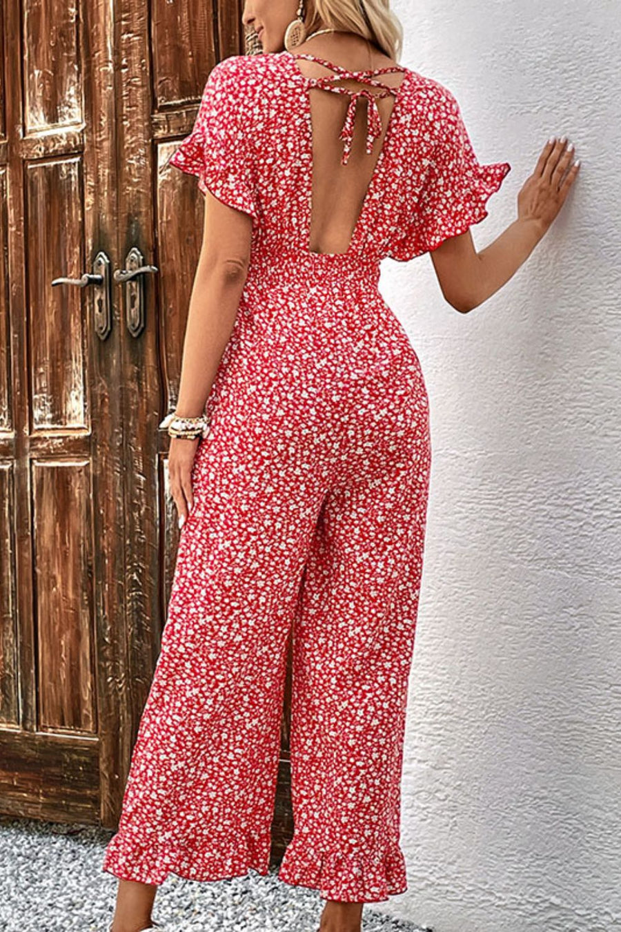 Floral backless jumpsuit with smocked bodice, tie back, and ruffled hem.