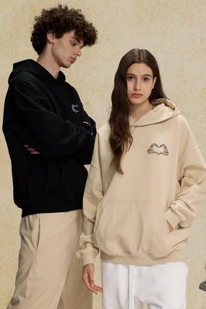 Beige oversized hoodie with embroidered heartbeat graphic on chest, front pocket.