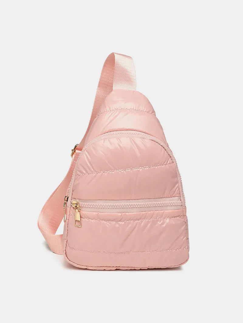 Glossy padded sling bag in pink with a single adjustable strap and gold zipper details.