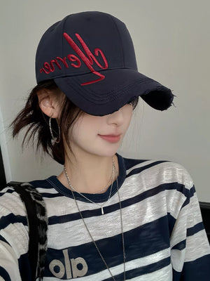 Navy blue distressed baseball cap with red embroidery and frayed brim.