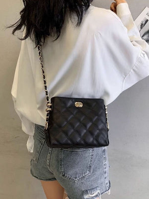 Black quilted PU leather crossbody bag with gold chain strap and turn-lock closure.