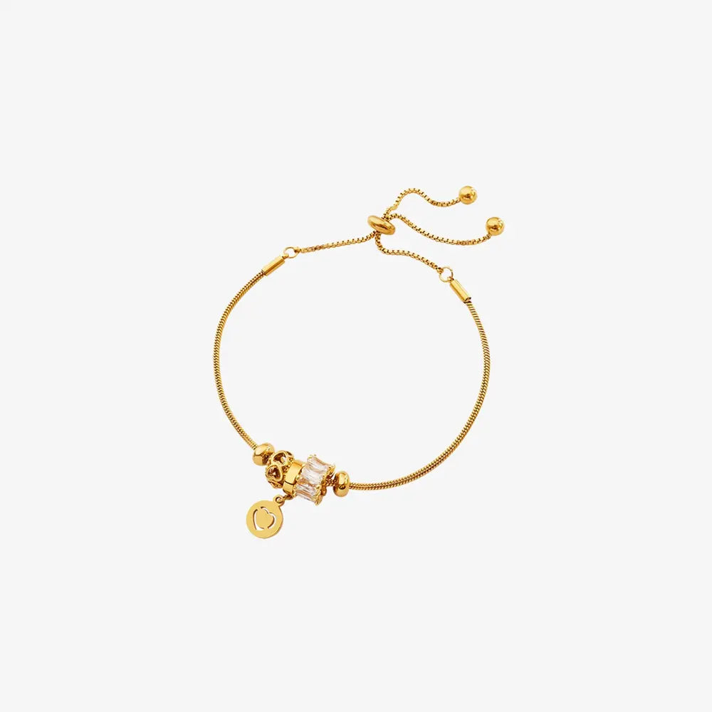 Gold slider bracelet with adjustable chain, cubic zirconia charm, and heart pendant.