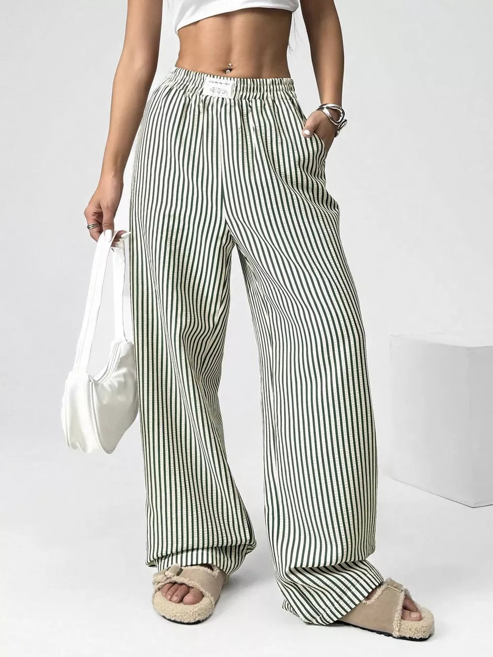 Green striped high-waisted wide-leg pants with drawstring detail.