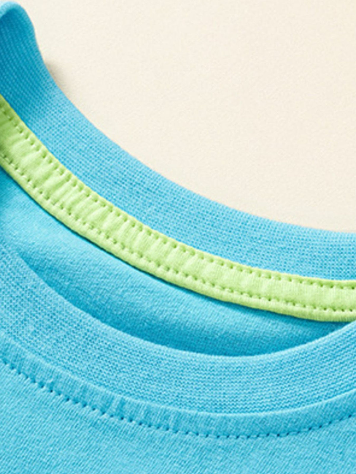 Blue cotton baby tee with lime green trim detail at the neckline.
