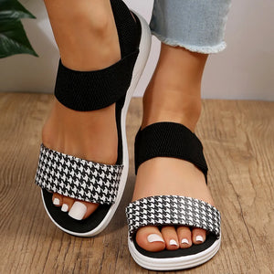 Geometric print elastic strap sandals in black and white houndstooth with black elastic straps.