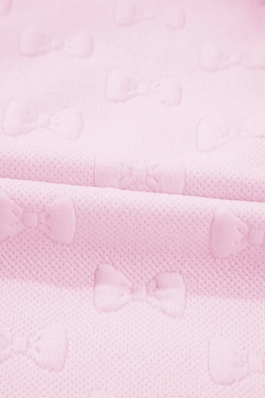 Blush pink loungewear set with embossed bow pattern and ruffle sleeves.