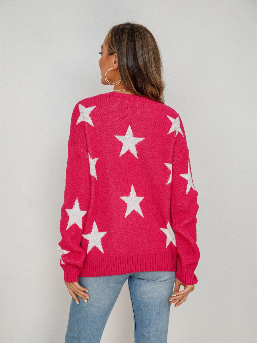 Pink knit crewneck sweater with white stars, long sleeves, ribbed cuffs and hem.