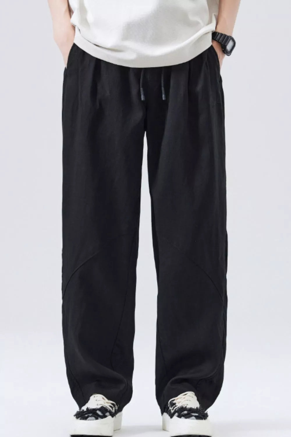 Black loose fit drawstring casual pants with a relaxed cut and subtle paneling.