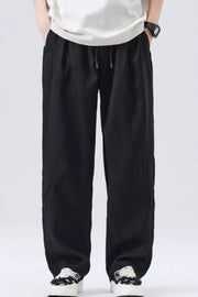 Black loose fit drawstring casual pants with a relaxed cut and subtle paneling.