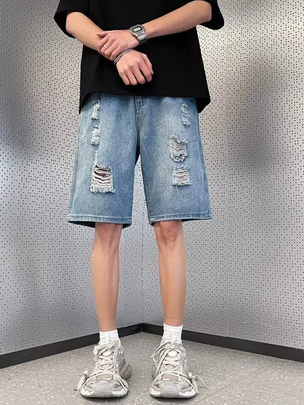 Men's light wash distressed denim wide leg shorts with ripped details.