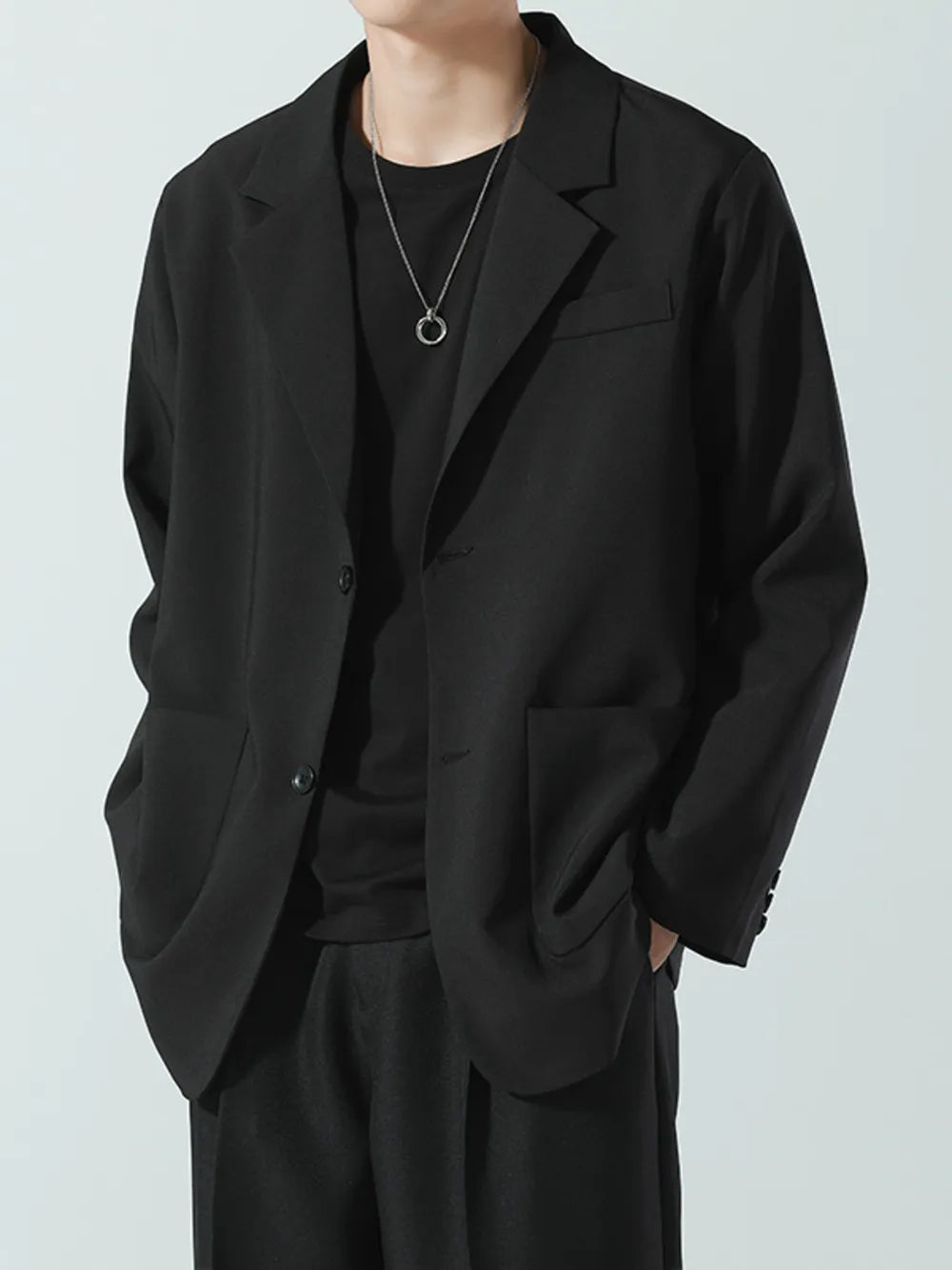 Black relaxed fit blazer with notch lapels and two button closure.
