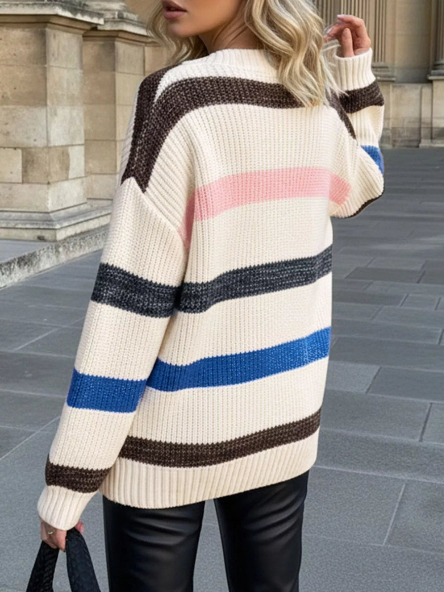 Oversized striped sweater in cream with brown, pink, grey, and blue stripes.