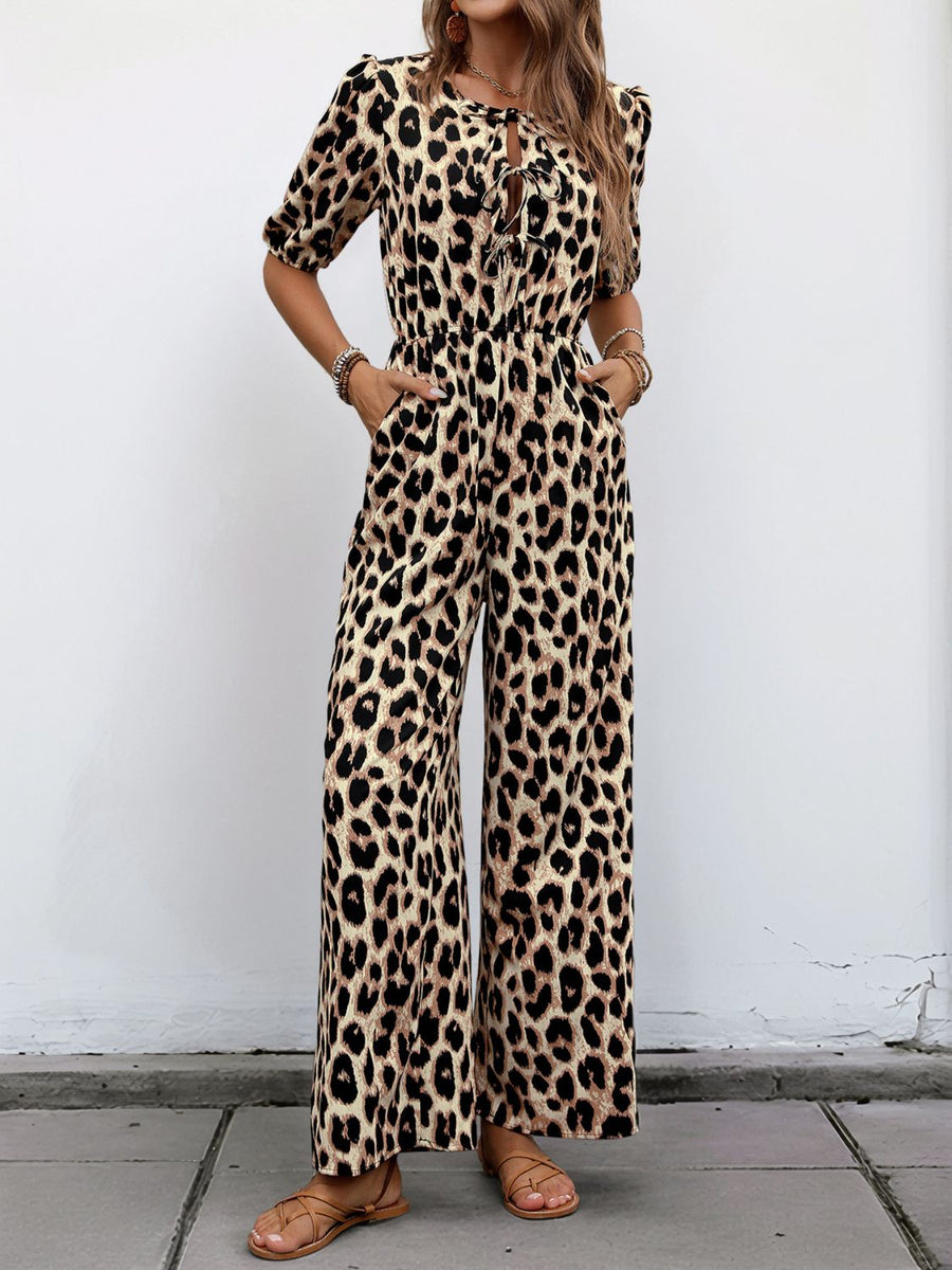 Leopard print jumpsuit with puff sleeves and tie-neck detail.