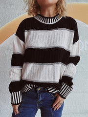 Black and white striped mock neck sweater with textured knit panels and ribbed cuffs.
