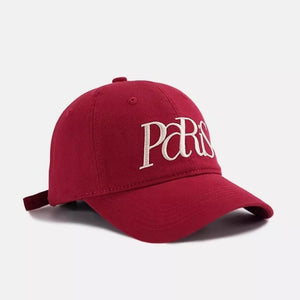 Red baseball cap with white embroidered Paris text and adjustable strap