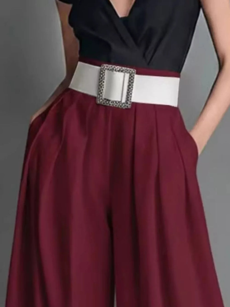Burgundy maternity pants with a white belted high waist and wide legs.