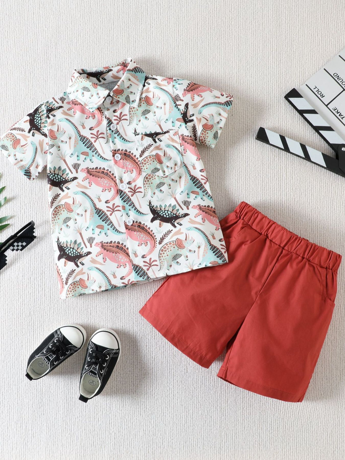 Toddler cotton shirt and shorts set with dinosaur print and red shorts.