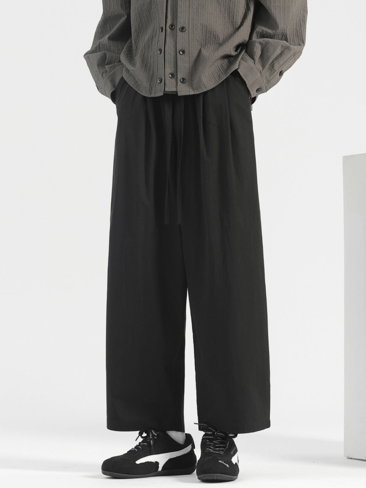 Men's black wide-leg drawstring casual trousers with a relaxed fit.