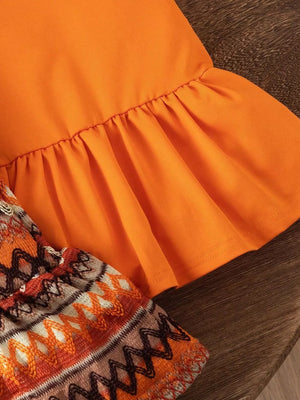 Orange baby halter dress with ruffled hem and patterned trim