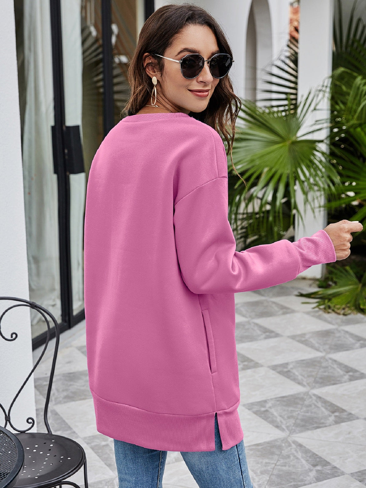 Oversized dusty pink sweatshirt with crewneck, side pockets, and side slits.