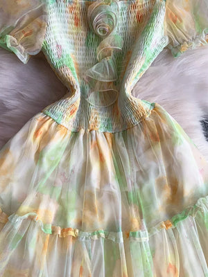 Floral tiered midi dress in green and sherbet with smocked bodice and ruffled details.
