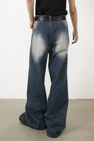 Faded wash palazzo jeans in medium denim with a wide leg and distressed detailing.