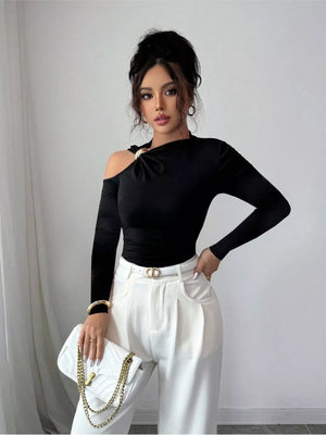 Black one-shoulder t-shirt with cutout detail and gold ring accent.