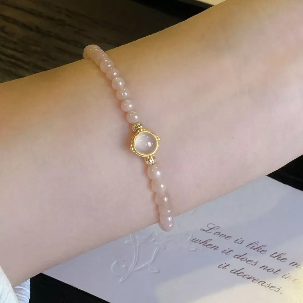 Moonstone Elegance gold-plated bracelet with blush pink beads and a central moonstone charm.