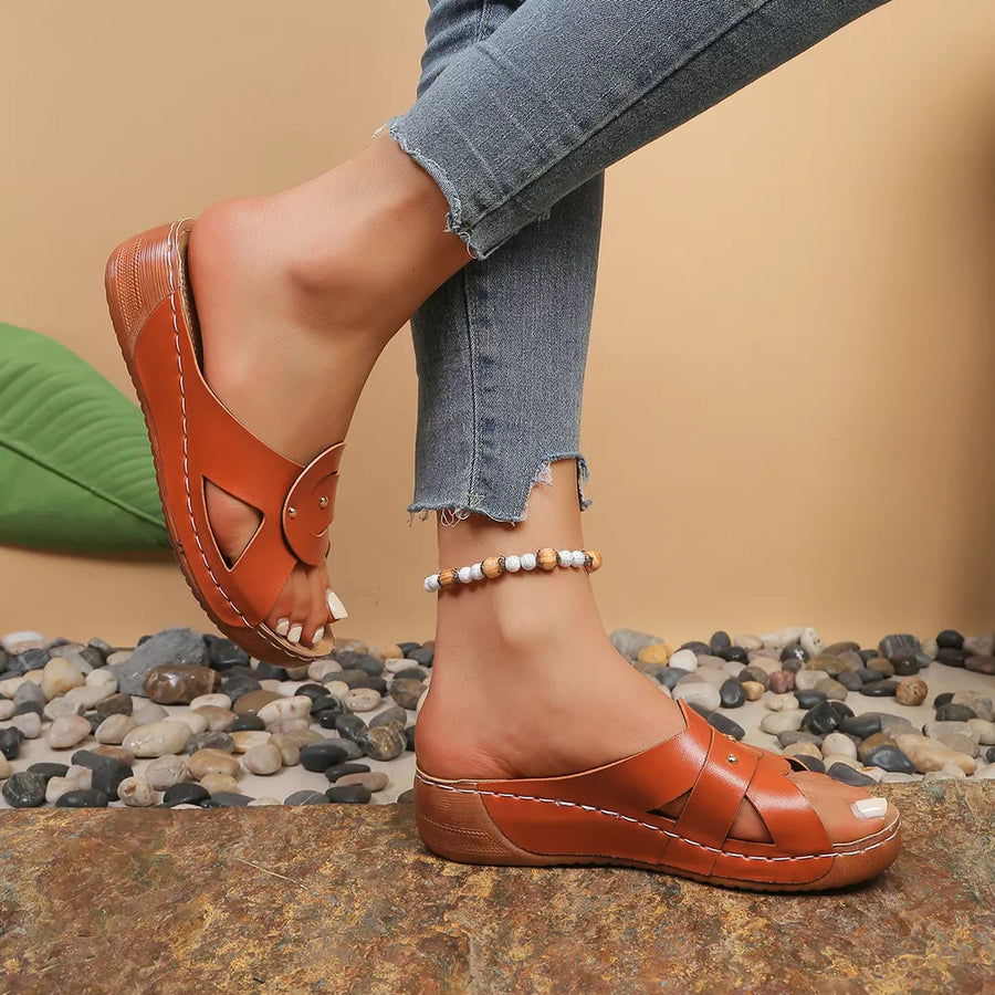 Brown embellished open-toe wedge sandals with decorative straps and white stitching.
