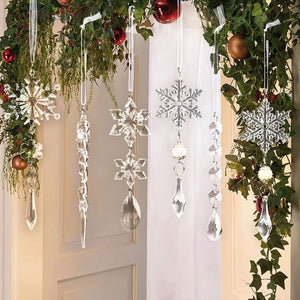 Transparent acrylic snowflake and icicle Christmas ornaments hang from greenery.
