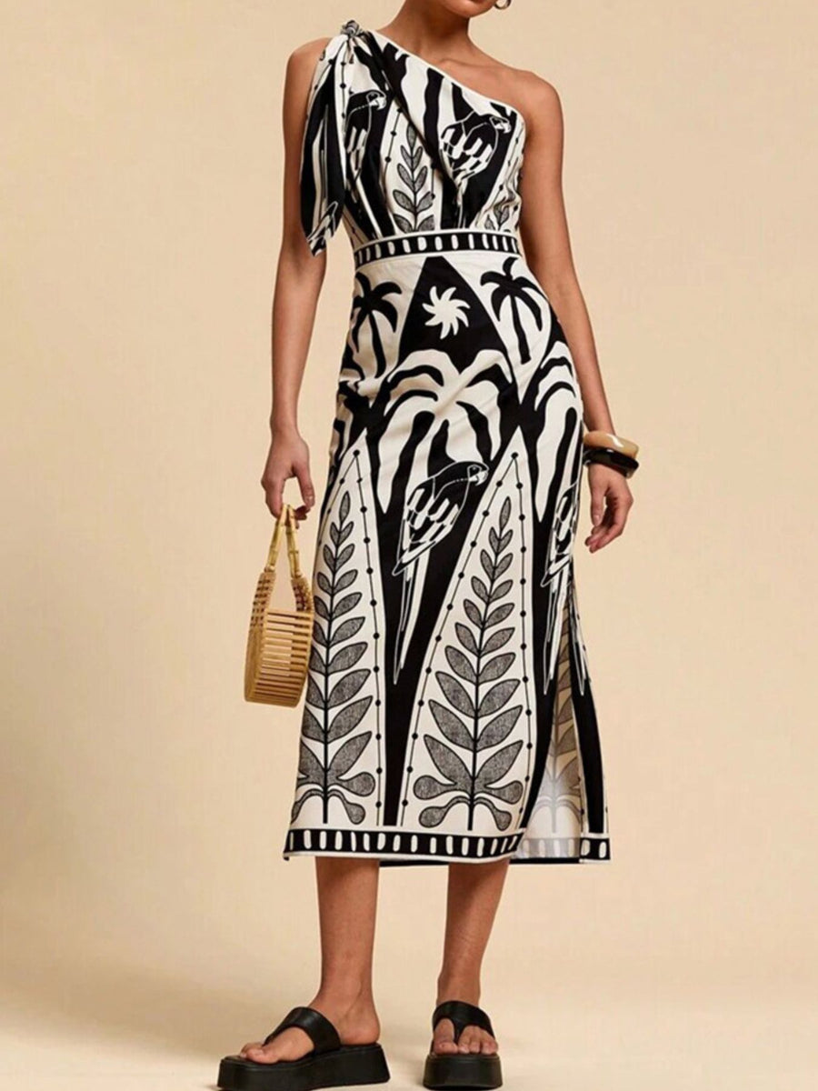 Black and white tropical print one-shoulder midi dress with defined waist and side slits.