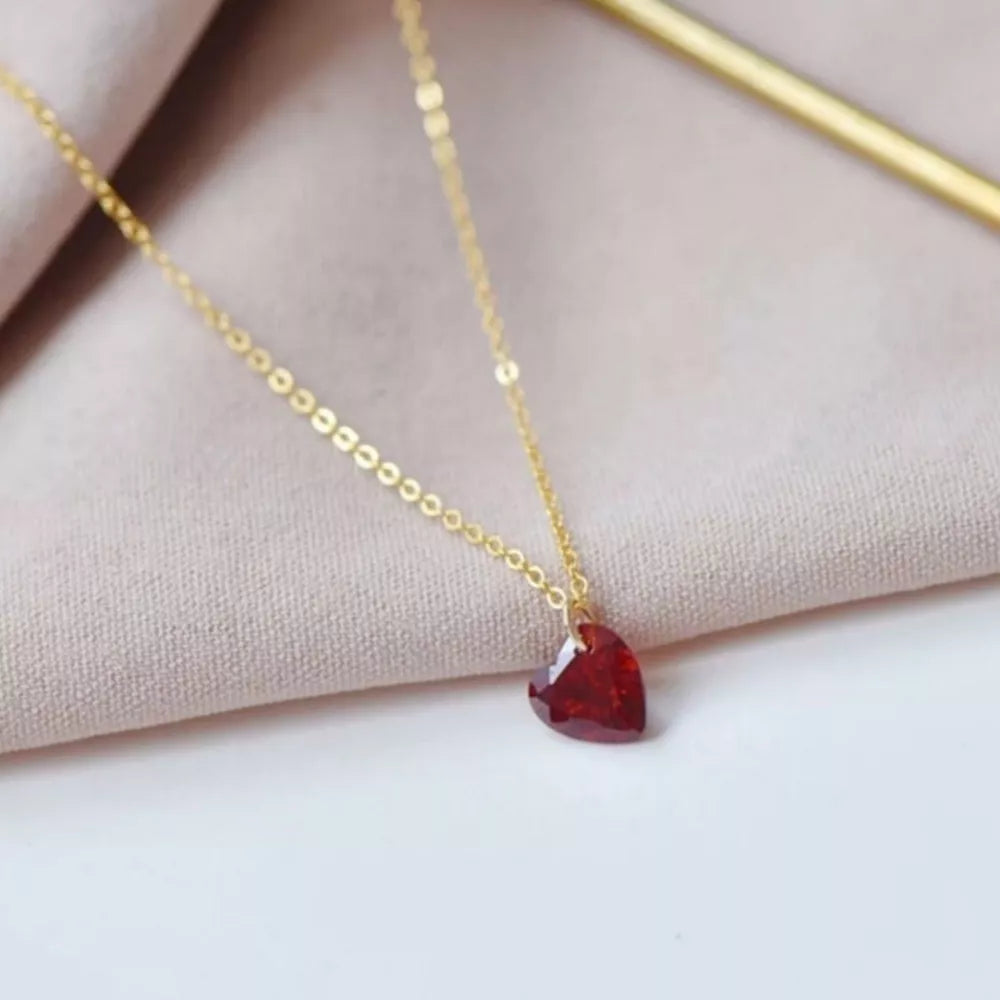 Gold chain necklace with a faceted red heart pendant