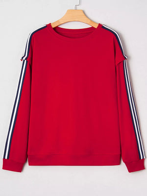 Red sweatshirt with varsity stripe detail on sleeves