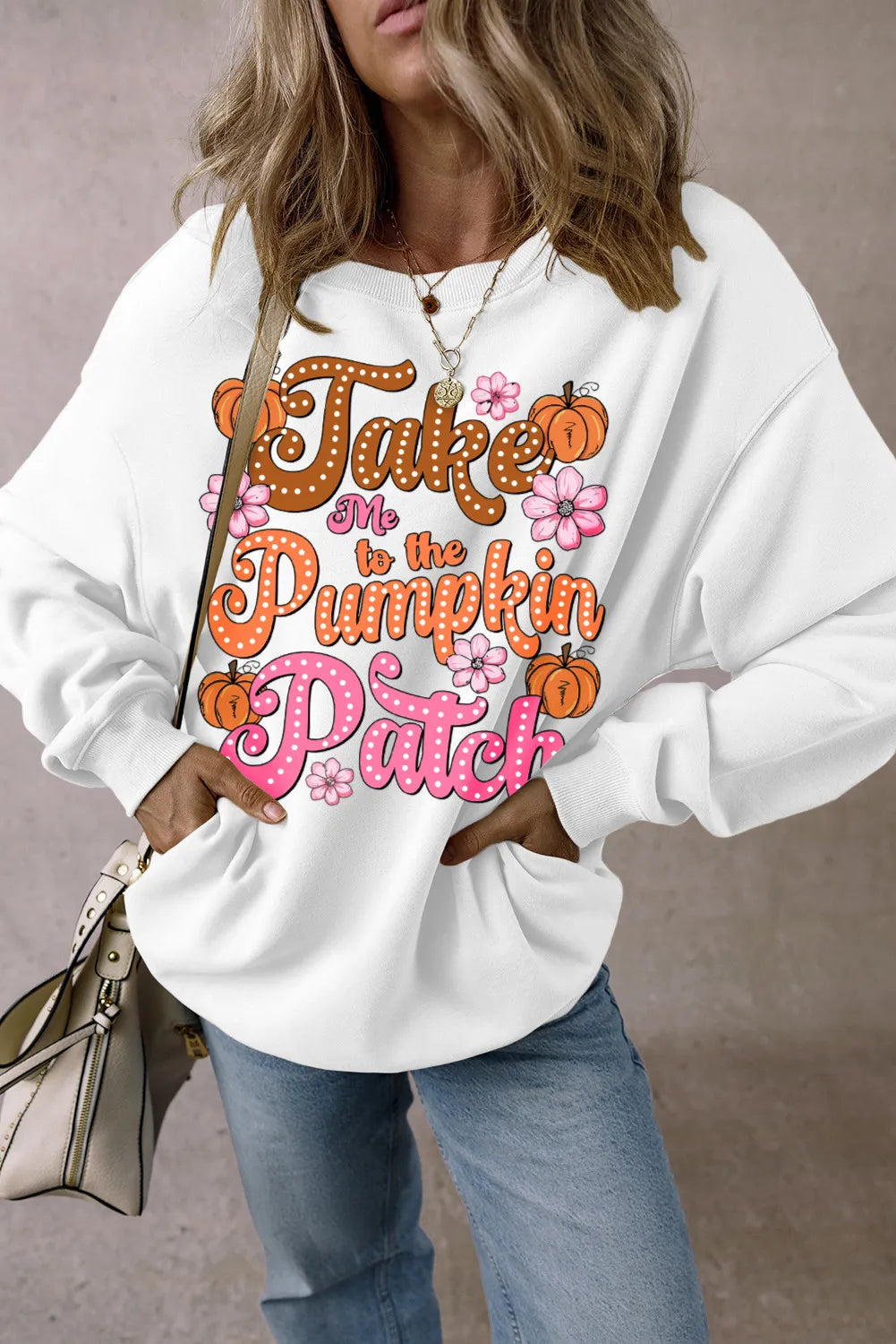 White long-sleeve sweatshirt with "Take Me to the Pumpkin Patch" graphic, pumpkins, and flowers.