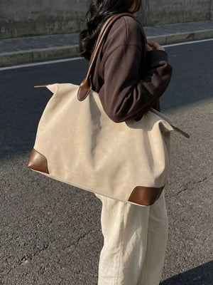 Chic slouchy travel bag in beige with camel leather accents and handles.