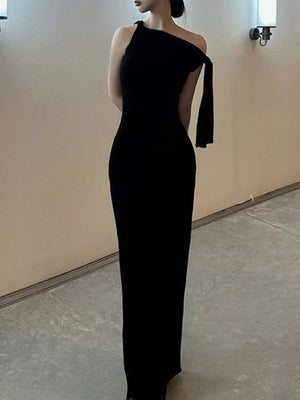 Black asymmetrical draped maxi dress with one shoulder and flowing detail.