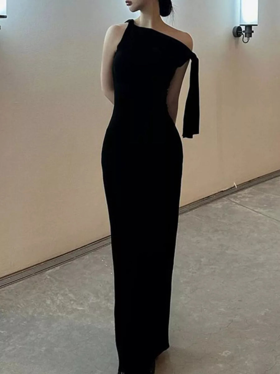 Black asymmetrical draped maxi dress with one shoulder and flowing detail.