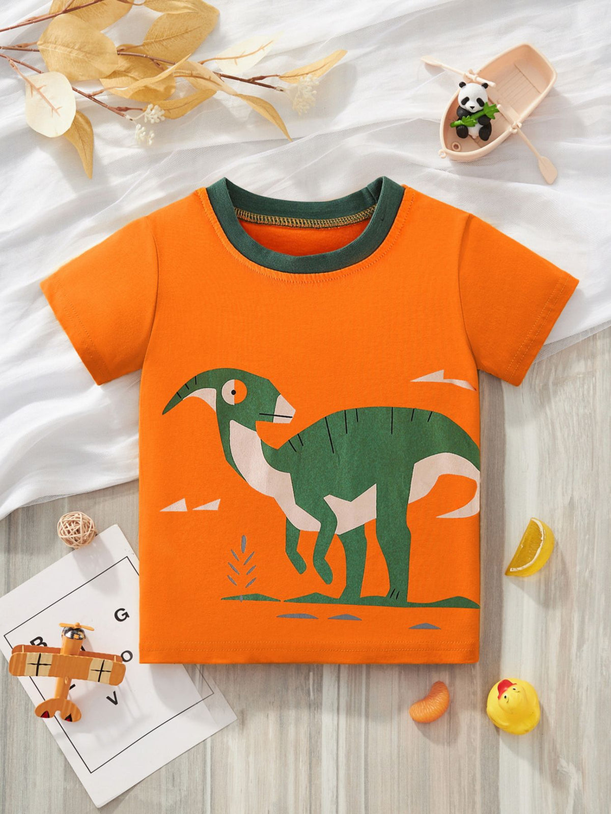 Orange cotton crew neck t-shirt with a green dinosaur graphic and green trim