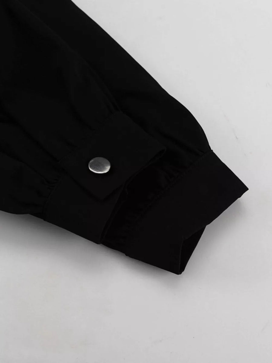 Black long sleeve shirt cuff with silver snap button detail