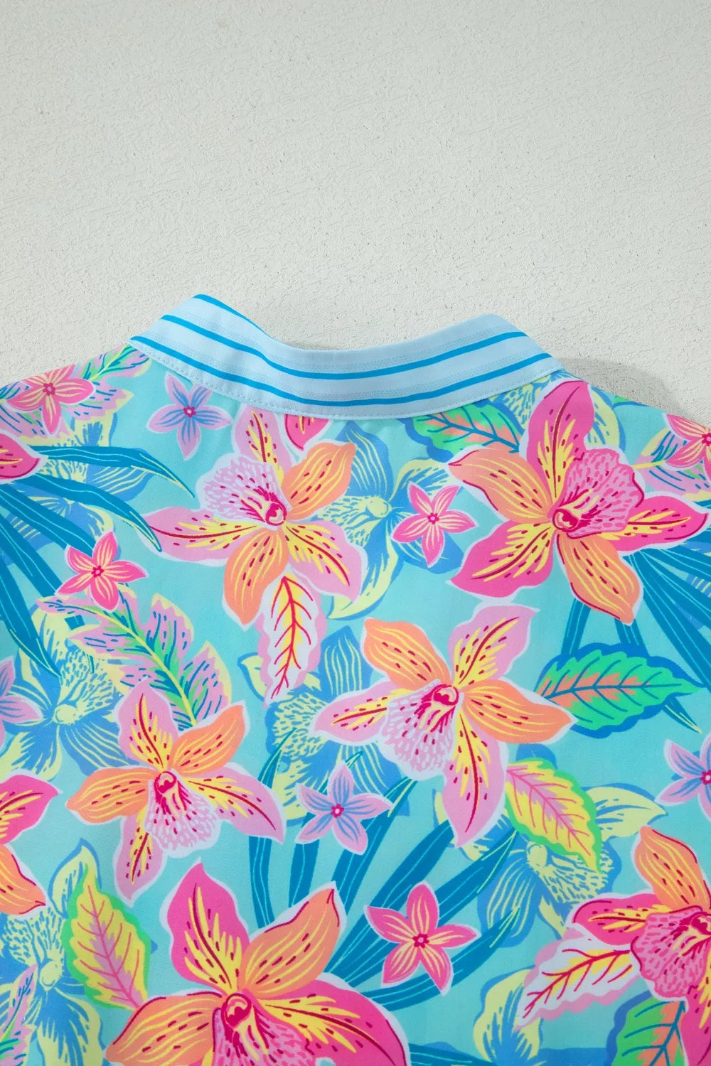 Tropical floral print dress with V-neck and scalloped trim detail.