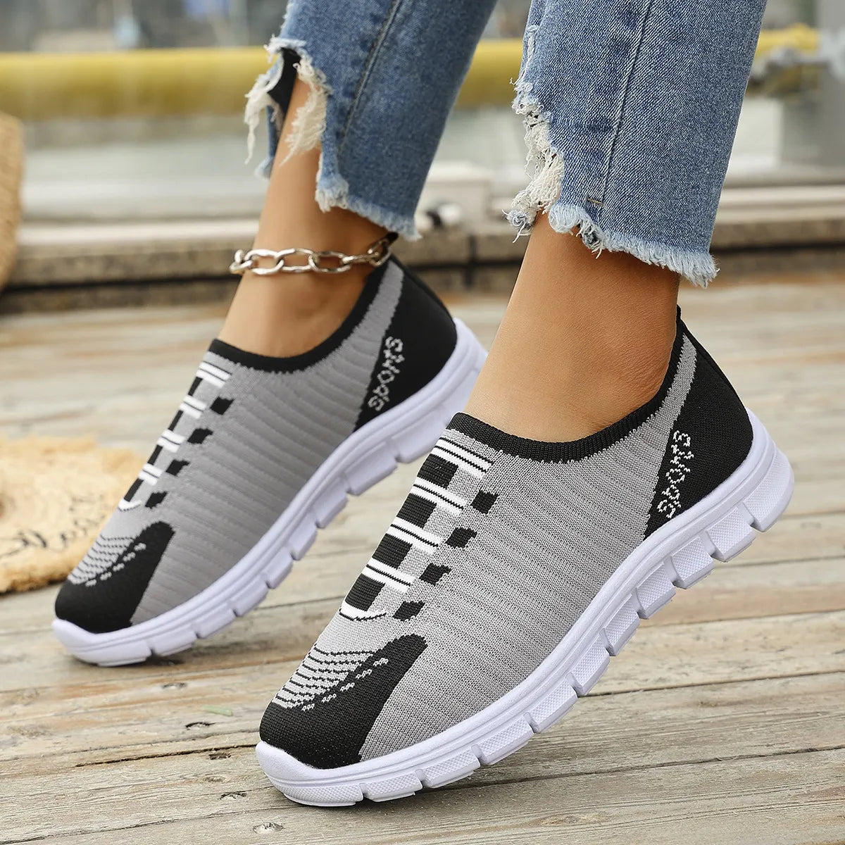 Ribbed knit slip-on sport sneakers in gray and black with white accents and "Sports" detail.