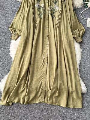 Khaki cotton maxi dress with embroidered floral detail and tie neck.