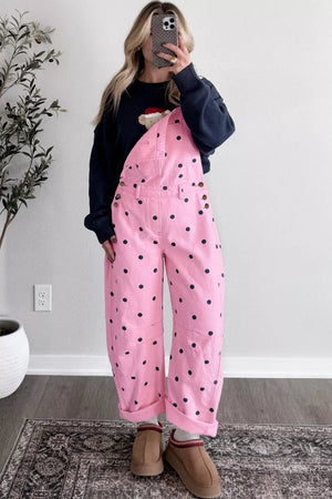 Pink denim overalls with black polka dots, bib pocket, and buttoned sides.
