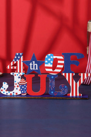 Patriotic wood block decor spells 4th of JULY with American flag and star patterns.