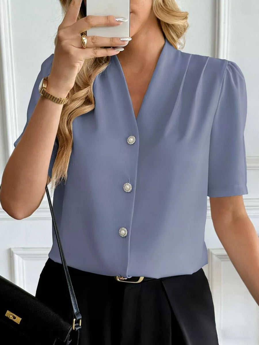 Blue V-neck button-down shirt with pearl buttons and short puff sleeves.