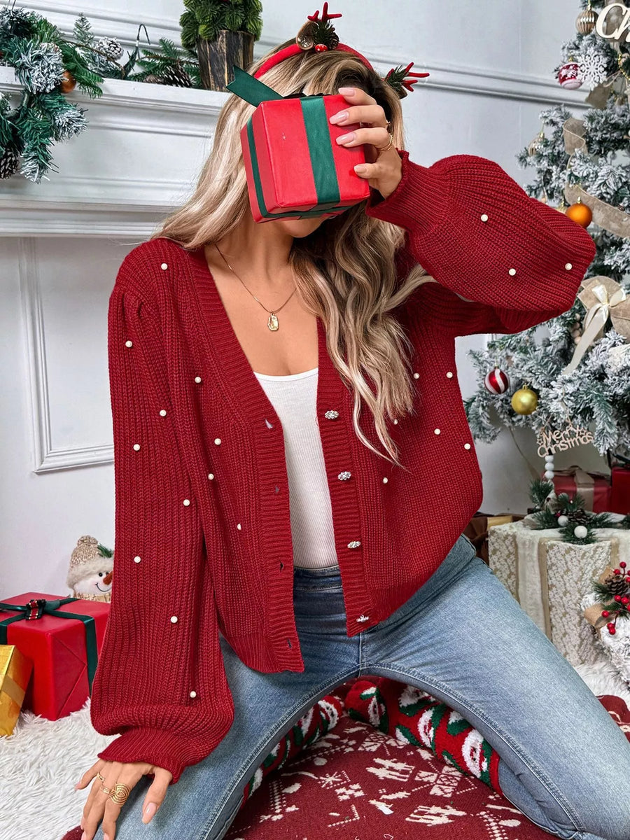 Red acrylic knit cardigan with pearl embellishments and balloon sleeves.