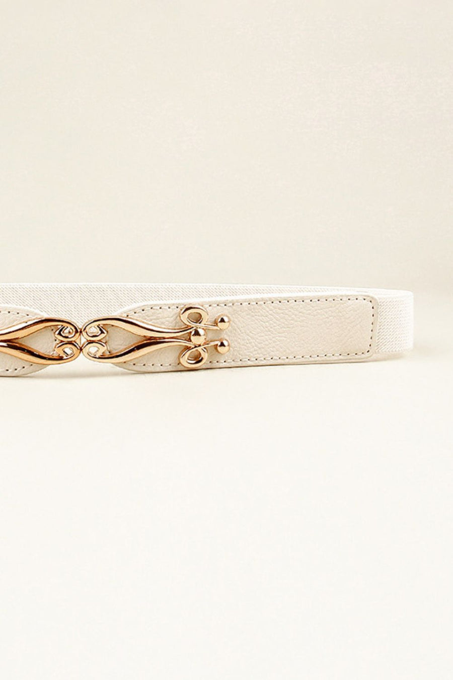 White elastic belt with a sculpted gold alloy clasp and faux leather accents