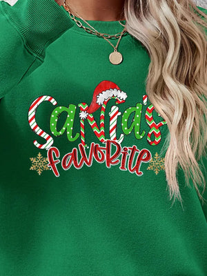 Green crewneck sweatshirt with Santa's Favorite graphic and snowflakes.