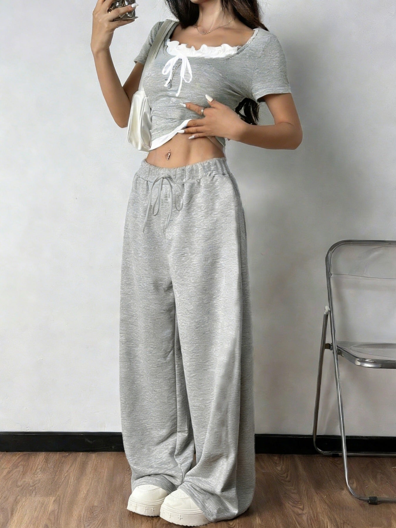 Grey tie front cropped top with white trim and drawstring wide-leg pants.