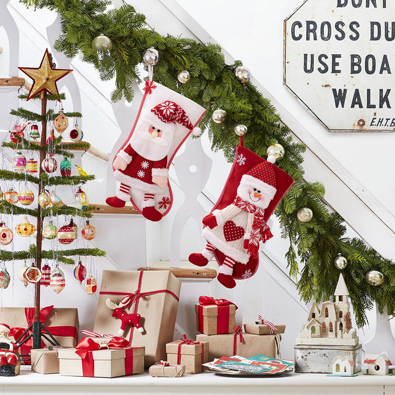 Festive plush Santa and Snowman Christmas stockings with embroidered details hang on a garland.